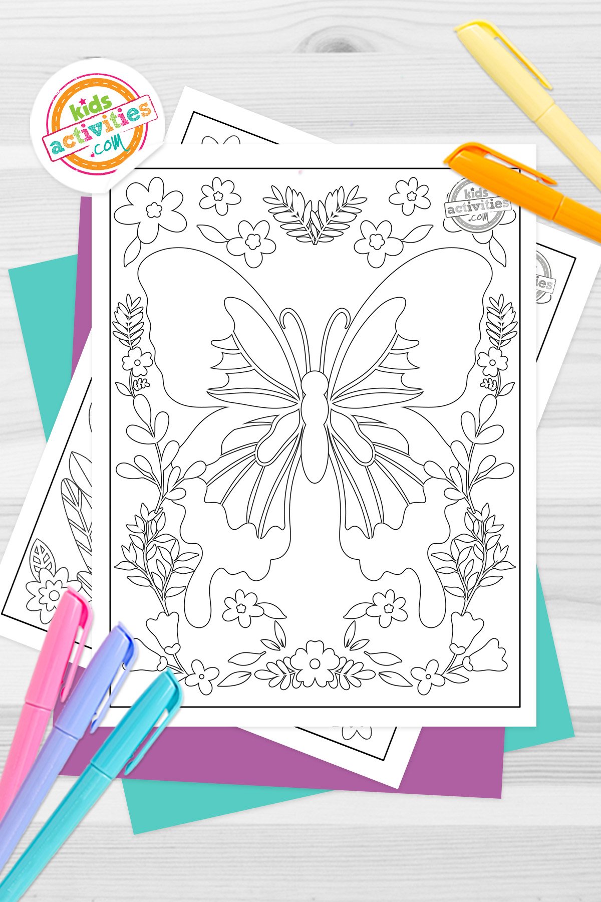 Black and white printed symmetry art coloring pages on top of blue-green and purple sheets with assorted markers on a dark grey background. printed pdf version from Kids activities blog.