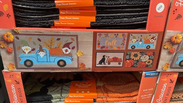 Costco fall rug- cardboard box showing 4 different rugs- hello fall, blue truck, dog and pumpkins, pumpkins and flowers